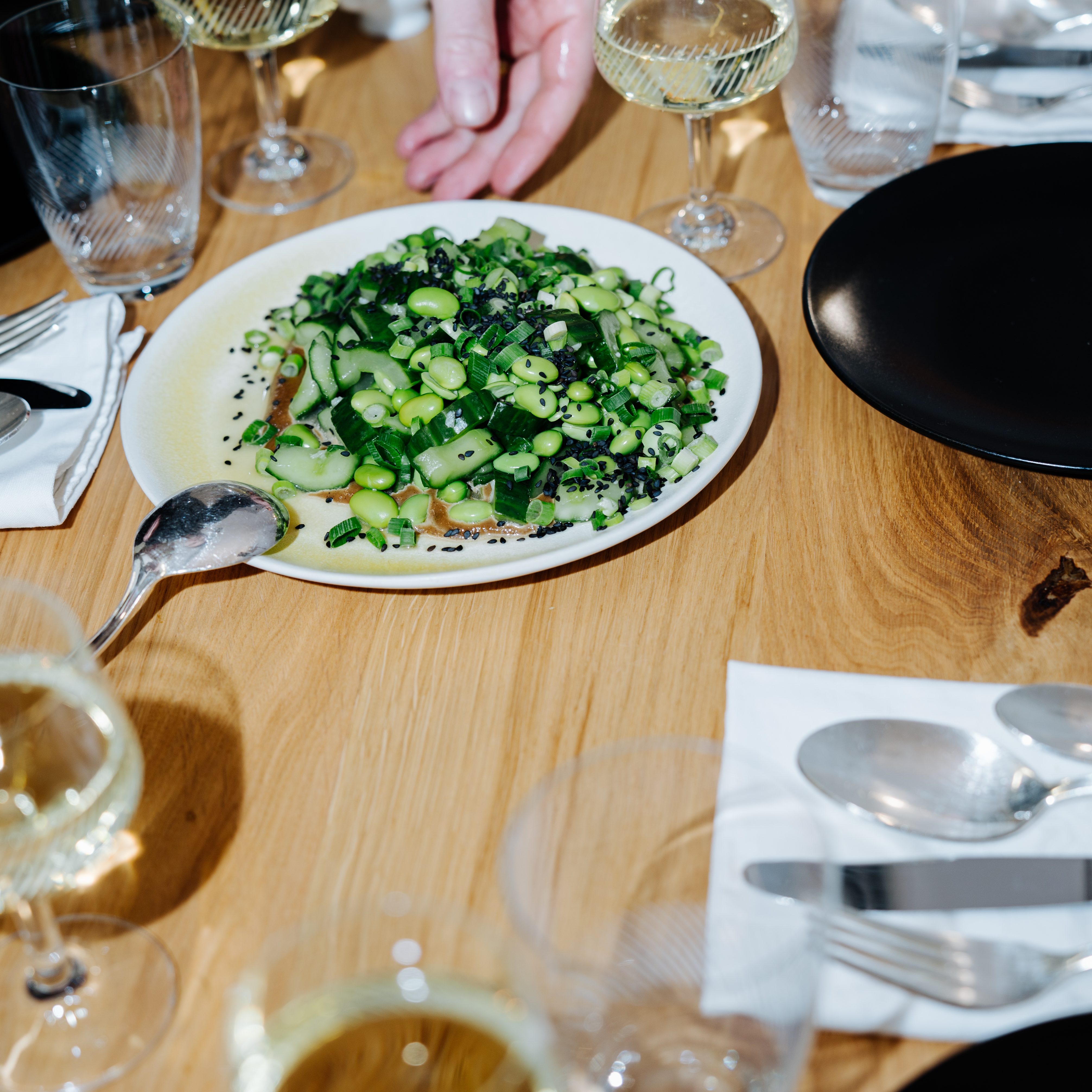 Exklusives Private Dining bei coca & EAT – gemeinsames Genießen eines mehrgängigen Menüs an einem handgefertigten Eichenholztisch in Berlin-Mitte.